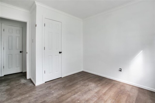 spare room with dark hardwood / wood-style flooring and ornamental molding