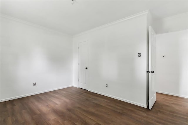 empty room with dark hardwood / wood-style floors and ornamental molding