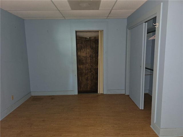 empty room with a paneled ceiling and light hardwood / wood-style floors