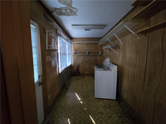 laundry area with wooden walls and washer / dryer