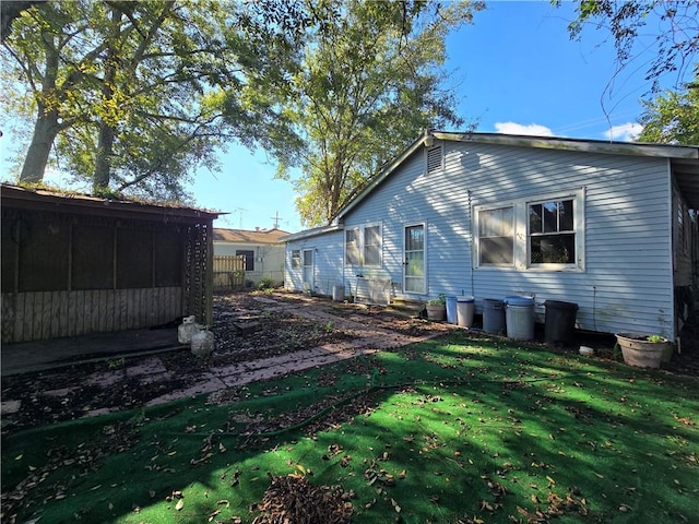 view of side of home with a yard and a sunroom