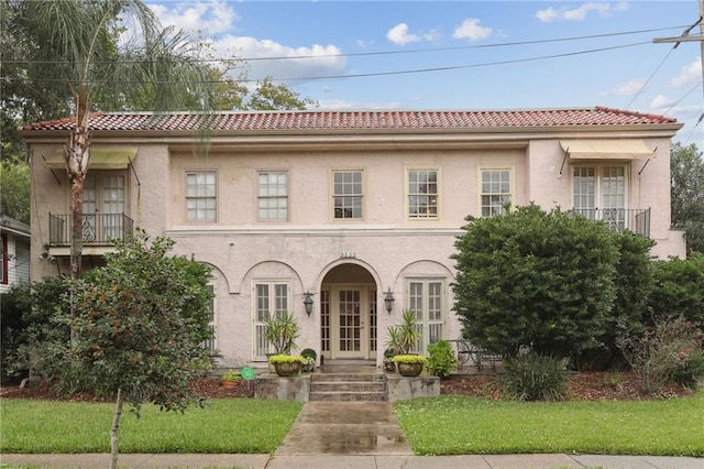 mediterranean / spanish house featuring a front lawn