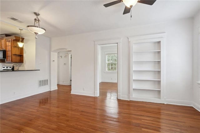 unfurnished living room with ceiling fan, built in features, and dark wood-type flooring