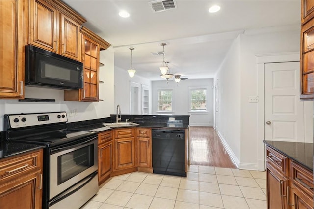 kitchen with pendant lighting, black appliances, sink, light tile patterned floors, and kitchen peninsula