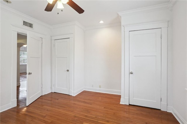 unfurnished bedroom with a closet, ceiling fan, hardwood / wood-style floors, and ornamental molding