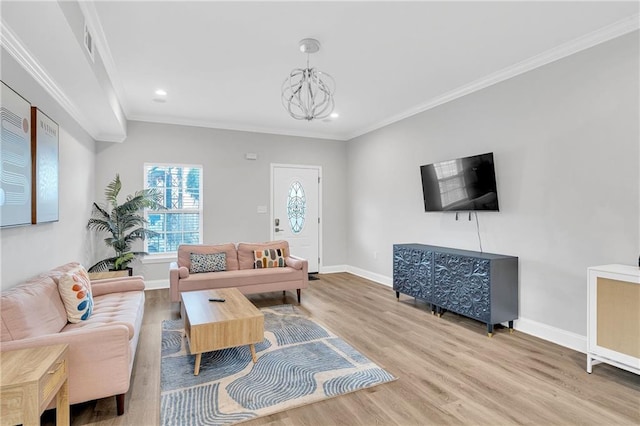 living room with crown molding, an inviting chandelier, and hardwood / wood-style flooring