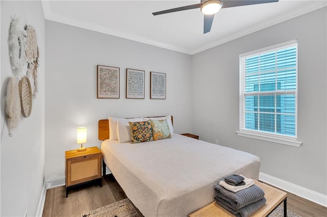 bedroom with ceiling fan, dark hardwood / wood-style flooring, and ornamental molding