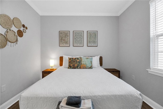 bedroom featuring multiple windows, dark hardwood / wood-style flooring, and ornamental molding