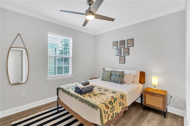 bedroom featuring wood-type flooring, ceiling fan, and ornamental molding