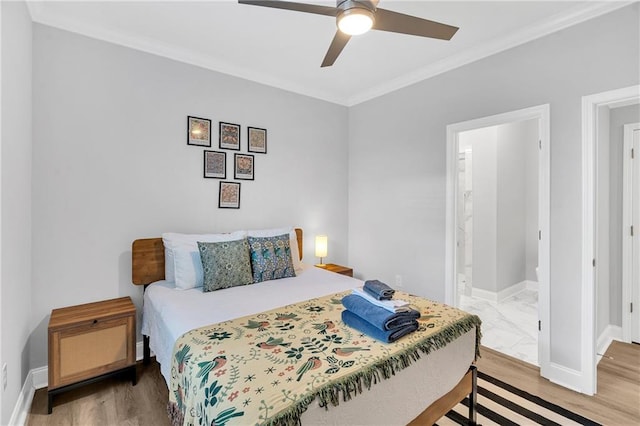 bedroom featuring connected bathroom, hardwood / wood-style flooring, ceiling fan, and ornamental molding