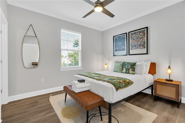 bedroom with hardwood / wood-style floors, ceiling fan, and crown molding