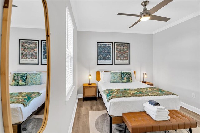 bedroom with wood-type flooring, ceiling fan, and crown molding