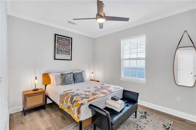 bedroom with wood-type flooring, ceiling fan, and crown molding