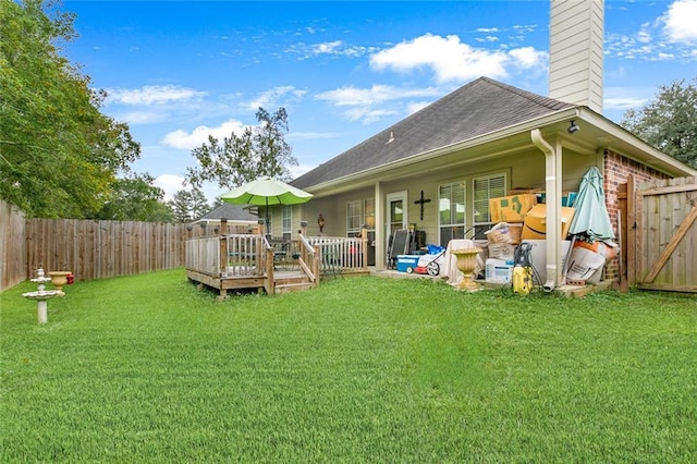 back of property with a yard and a wooden deck