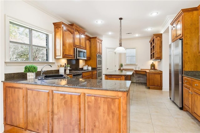 kitchen with hanging light fixtures, sink, stainless steel appliances, and kitchen peninsula