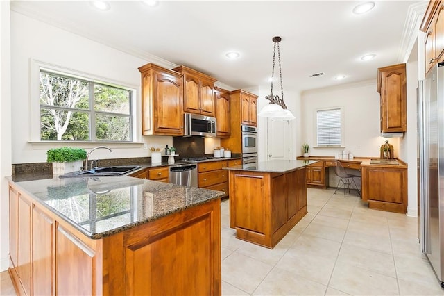 kitchen featuring sink, crown molding, decorative light fixtures, a center island, and stainless steel appliances