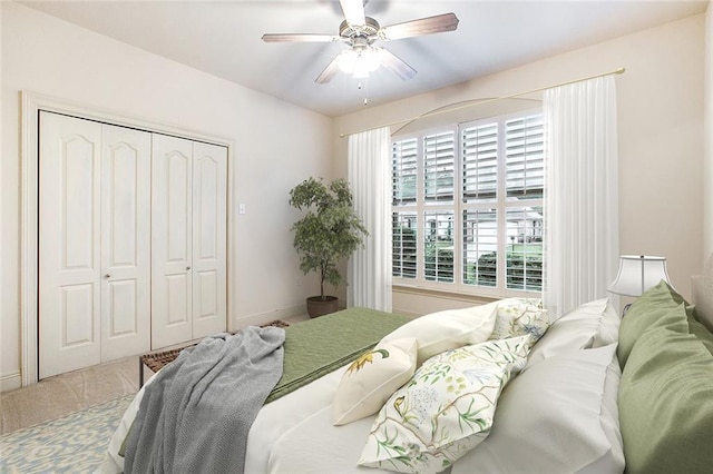 carpeted bedroom with ceiling fan and a closet