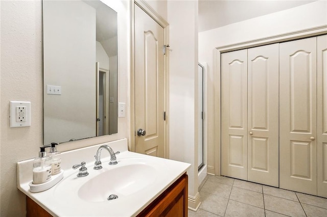 bathroom featuring tile patterned flooring, vanity, and walk in shower