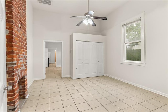 unfurnished bedroom with ceiling fan, light tile patterned floors, and a closet