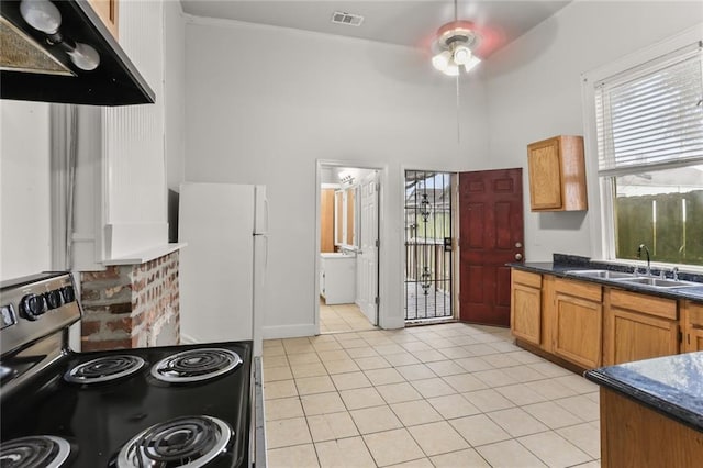 kitchen featuring stainless steel electric range oven, sink, ceiling fan, white fridge, and light tile patterned flooring