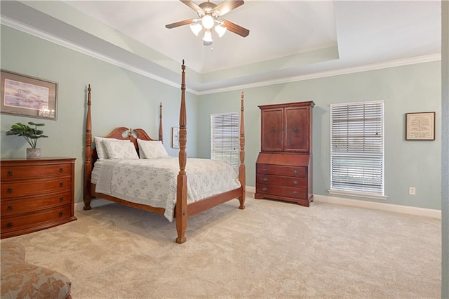 carpeted bedroom featuring a tray ceiling, ceiling fan, and ornamental molding