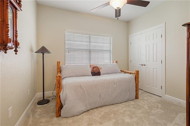 carpeted bedroom featuring ceiling fan and a closet