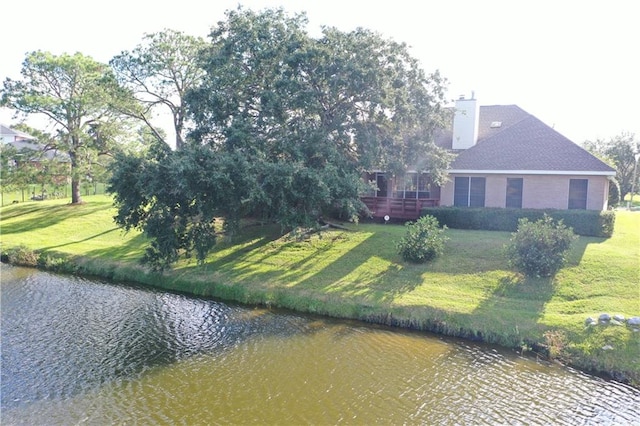 exterior space featuring a yard and a deck with water view