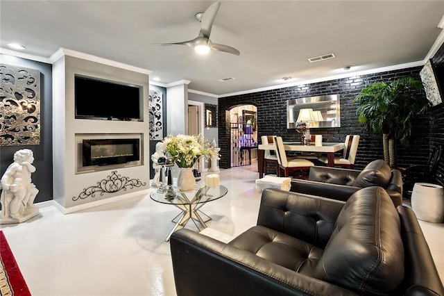 living room featuring ceiling fan, brick wall, and ornamental molding