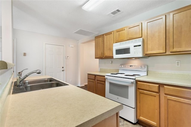 kitchen with a textured ceiling, white appliances, and sink