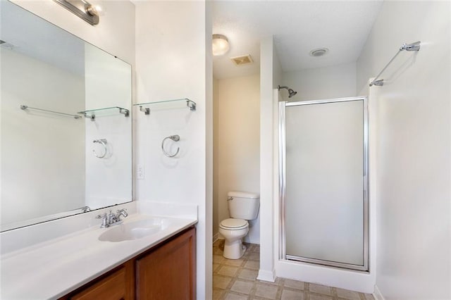 bathroom with a shower with door, vanity, and toilet