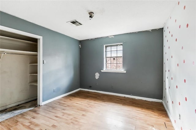 unfurnished bedroom featuring light hardwood / wood-style floors and a closet