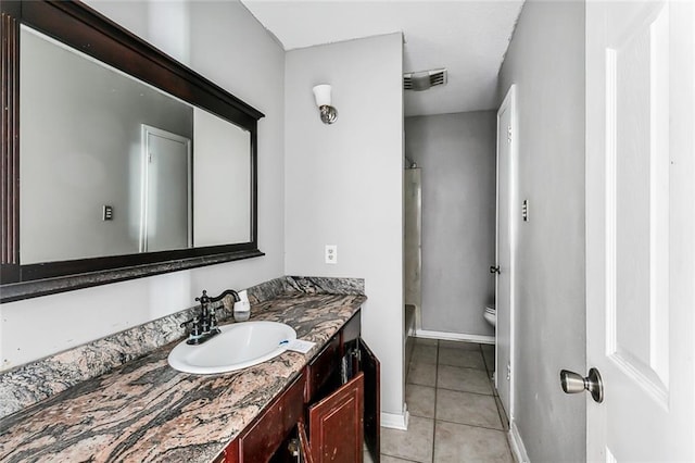 bathroom with tile patterned flooring, vanity, and toilet