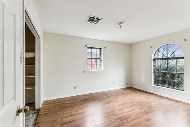 unfurnished room with hardwood / wood-style floors and a healthy amount of sunlight