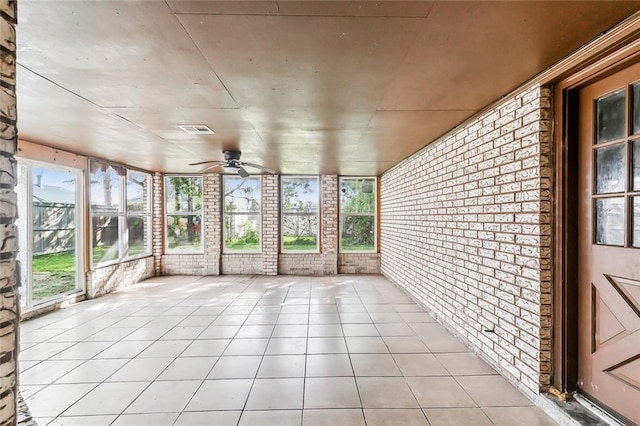 unfurnished sunroom with ceiling fan