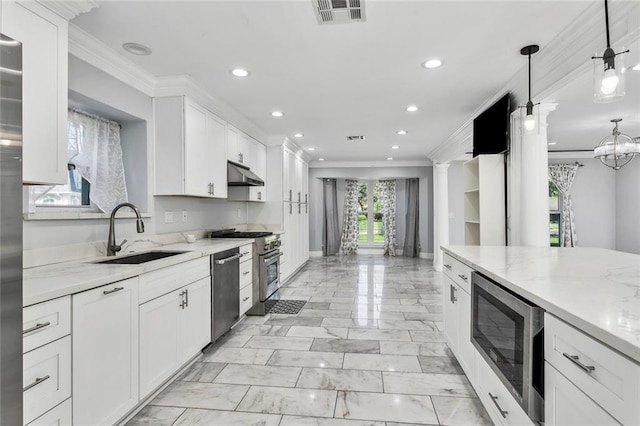 kitchen with decorative columns, white cabinetry, sink, and stainless steel appliances