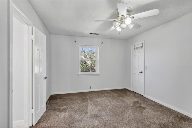 carpeted spare room with a textured ceiling and ceiling fan