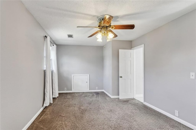 carpeted spare room featuring ceiling fan and a textured ceiling