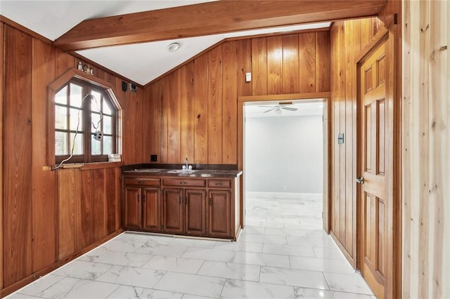 kitchen with ceiling fan, sink, french doors, lofted ceiling with beams, and wood walls