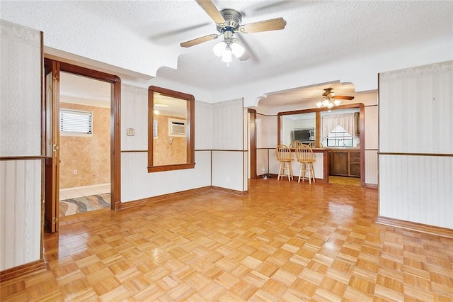 spare room with ceiling fan, light parquet flooring, and a textured ceiling