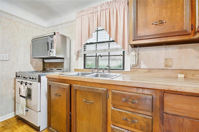 kitchen featuring sink, white stove, and light parquet flooring