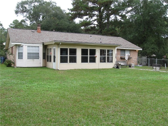 rear view of property featuring a yard