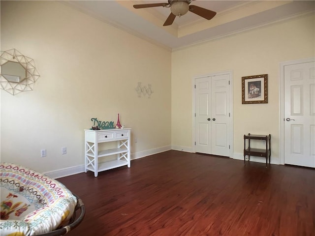 sitting room with a raised ceiling, crown molding, ceiling fan, and dark hardwood / wood-style floors