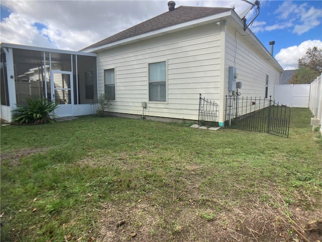 rear view of house with a sunroom and a lawn