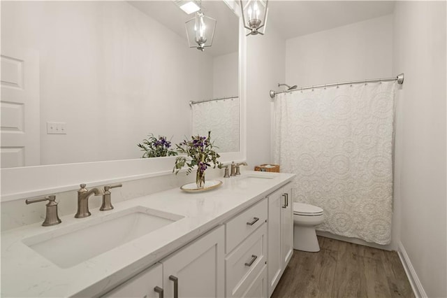 bathroom with an inviting chandelier, a shower with curtain, hardwood / wood-style floors, toilet, and vanity