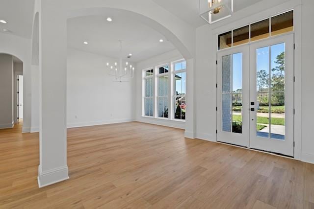 foyer entrance featuring an inviting chandelier, light wood-type flooring, and french doors