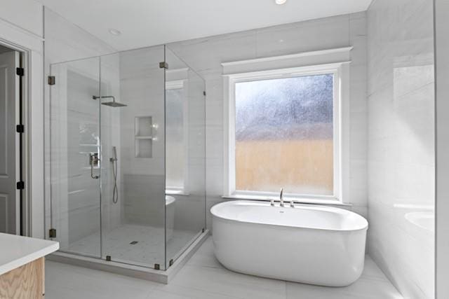 bathroom with vanity, plus walk in shower, and a wealth of natural light