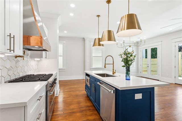 kitchen with sink, hanging light fixtures, blue cabinetry, white cabinetry, and stainless steel appliances