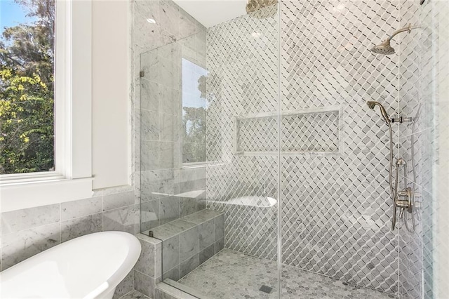 bathroom with shower with separate bathtub and tile walls