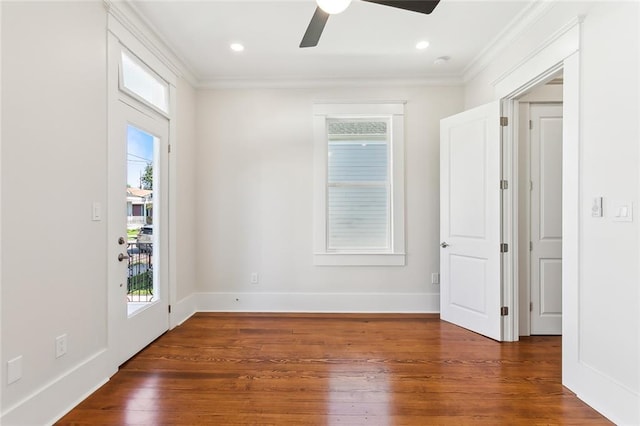 spare room with ceiling fan, ornamental molding, dark wood-type flooring, and a wealth of natural light