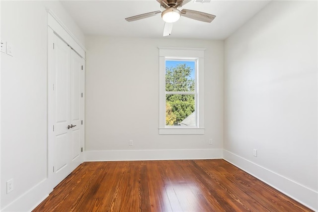 spare room featuring ceiling fan and dark wood-type flooring